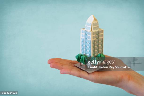 origami condo in my hand - wealth creation stock pictures, royalty-free photos & images