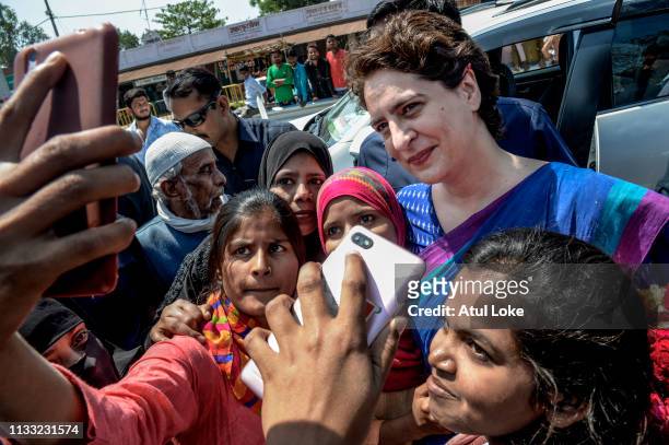 Young women pose for a selfie with Congress Party's Priyanka Gandhi during her campaign on March 27, 2019 in Uttar Pradesh, India. Congress leader...
