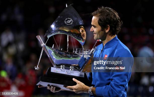 Roger Federer of Switzerland poses with the winners trophy after victory during day fourteen of the Dubai Duty Free Championships at Dubai Tennis...