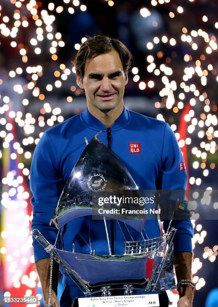 Roger Federer of Switzerland poses with the winners trophy after victory during day fourteen of the Dubai Duty Free Championships at Dubai Tennis...