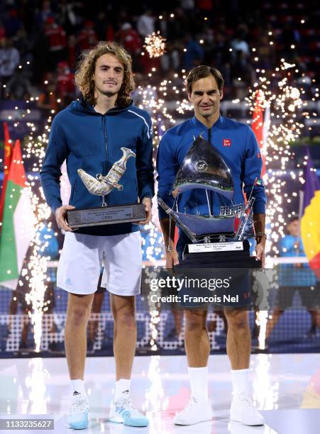 Stefanos Tsitsipas of Greece, runner up and Roger Federer of Switzerland, winner pose with their trophies after the Dubai Duty Free Championships at...