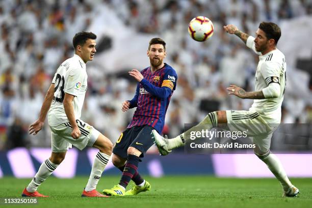 Lionel Messi of Barcelona is clowed down by Sergio Reguilon and Sergio Ramos of Real Madrid during the La Liga match between Real Madrid CF and FC...