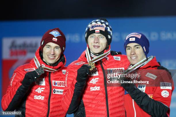 Silver medalist Kamil Stoch of Poland, gold medalist Dawid Kubacki of Poland and bronze medalist Stefan Kraft of Austria celebrates with their medals...