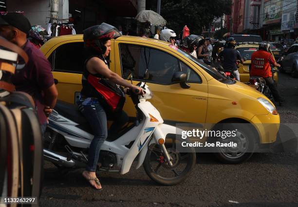 People pass through the streets of a shopping district as the city deals with the influx of Venezuelans that are crossing the border on March 2, 2019...