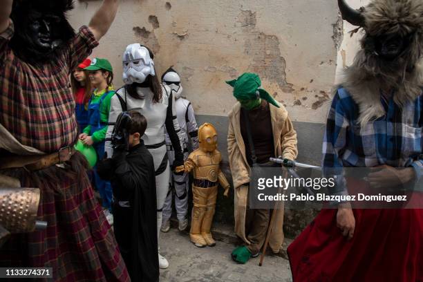 Children dressed as Star Wars characters watch at men carrying billy goats’ horns and goat skins known as ‘Trangas’ during Bielsa traditional...