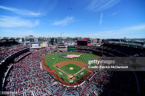 General view as members of the New York Mets and Washington Nationals line the baselines as they listen to the playing of the national anthem on...