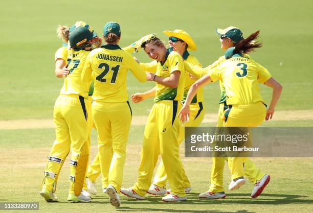 Georgia Wareham and Ellyse Perry of Australia celebrate with their teammates after dismissing Lauren Down of New Zealand during game three of the One...