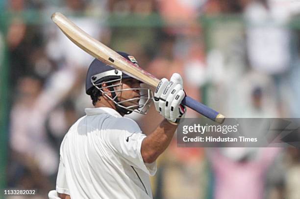 Indian batsman Sachin Tendulkar raises his bat after scoring fifty during the first day of the third Test match between Australia and India at Feroz...