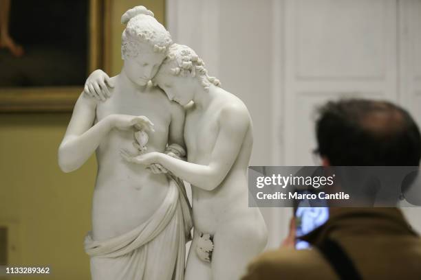 Tourist takes a picture of the statue of "Cupid and Psyche Standing", by the sculptor Canova, inside the exhibition at the Archaeological Museum of...