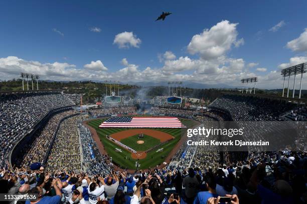 Fans cheer as a Boeing C-17 Globemaster III military transport aircraft conducts a flyover from the 452nd Air Mobility Wing from March Air Reserve...