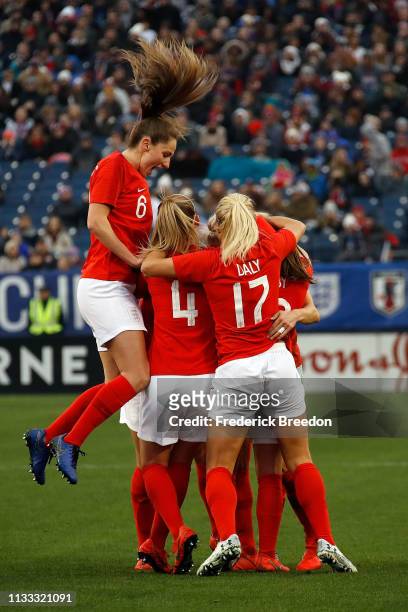 Abbie McManus of England jumps over teammates Keira Walsh and Rachel Daley after a goal in the 2019 SheBelieves Cup match between USA and England at...