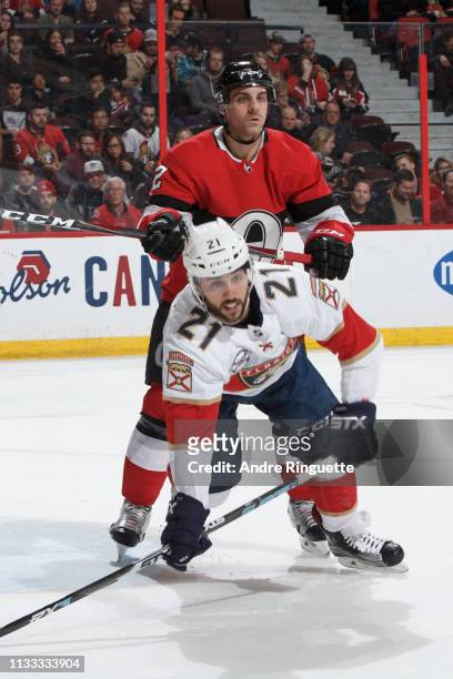 Dylan DeMelo of the Ottawa Senators cross checks Vincent Trocheck of the Florida Panthers at Canadian Tire Centre on March 28, 2019 in Ottawa,...
