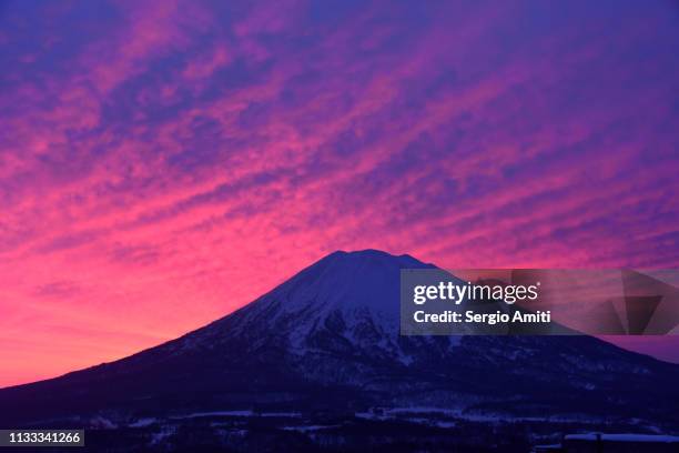 mount yotei with a deep red sky at dawn - vulkan yotei stock-fotos und bilder