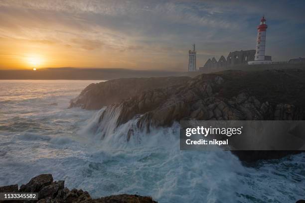 lighthouse pointe de saint-mathieu, sunset big waves, brittany (bretagne), france - finistere stock pictures, royalty-free photos & images