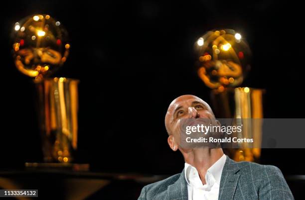 Manu Ginobili watches film on his career where his number was retired, in the background are two of the four championship trophies he won with the...