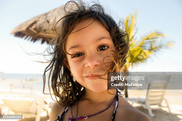 petite fille faisant un visage drôle à la plage - enfants plage photos et images de collection