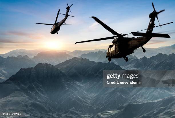 militärhubschrauber fliegen gegen sonnenuntergang - militärhubschrauber stock-fotos und bilder