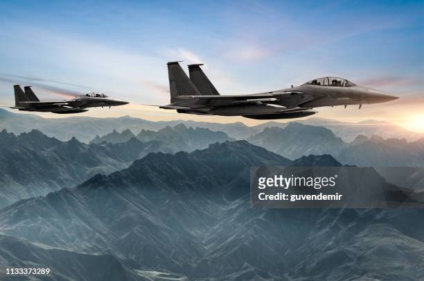aviones figher volando sobre las montañas neblina al atardecer - industria de la defensa fotografías e imágenes de stock