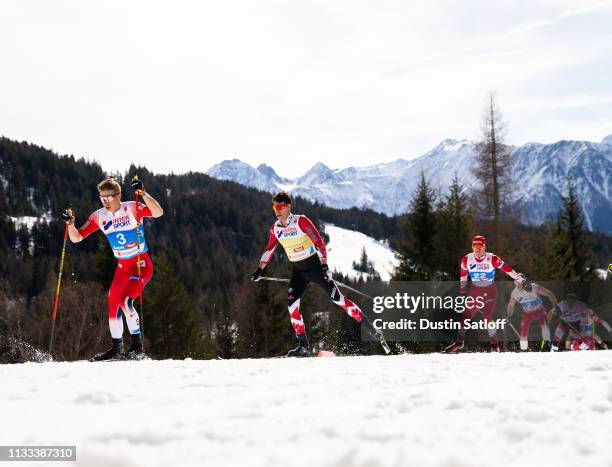 Simen Hegstad Krueger of Norway and Alex Harvey of Canada competes in the Men's 50km Cross Country mass start during the FIS Nordic World Ski...