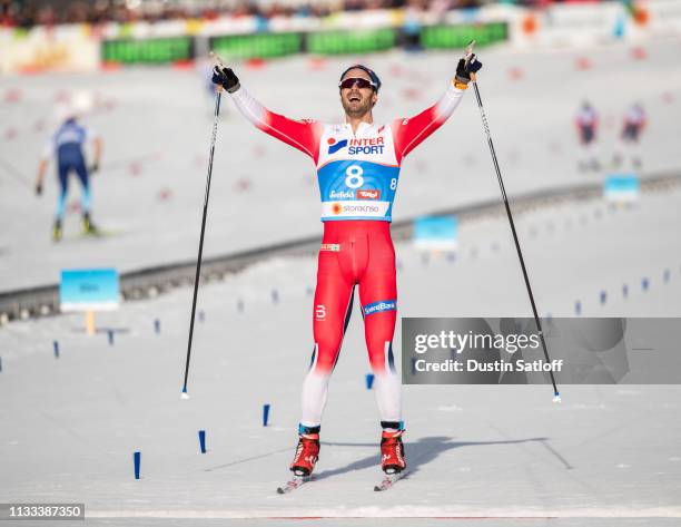 Hans Christer Holund of Norway celebrates as he crosses the finish line in first place in the Men's 50km Cross Country mass start during the FIS...