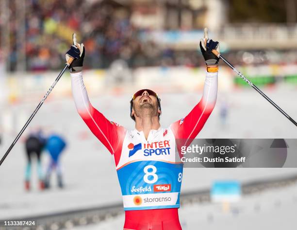 Hans Christer Holund of Norway celebrates as he crosses the finish line in first place in the Men's 50km Cross Country mass start during the FIS...