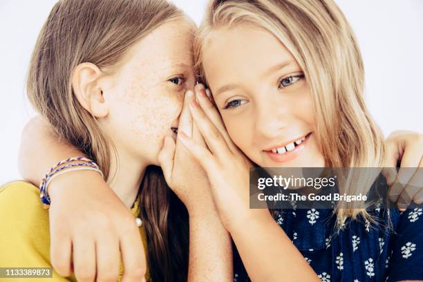 girl whispering to friend - child whispering stock-fotos und bilder