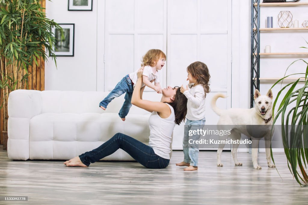 Little kids girls are beautiful and cute with mother and pet dog at home together happy