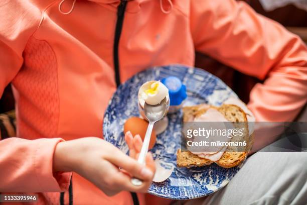 young women eating breakfast before going on a run - hard boiled eggs stock-fotos und bilder