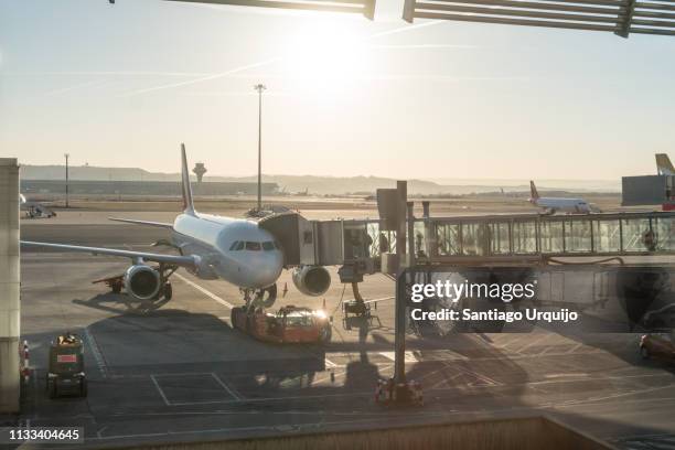 passengers boarding an airplane through a boarding bridge - madrid airport stock pictures, royalty-free photos & images