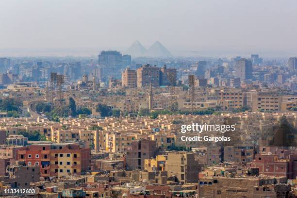 pyramids silhouettes over cairo, egypt - cairo city stock pictures, royalty-free photos & images