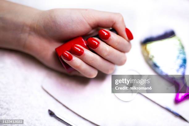 freshly painted red nails with manicure equipment around - gel effect stock pictures, royalty-free photos & images