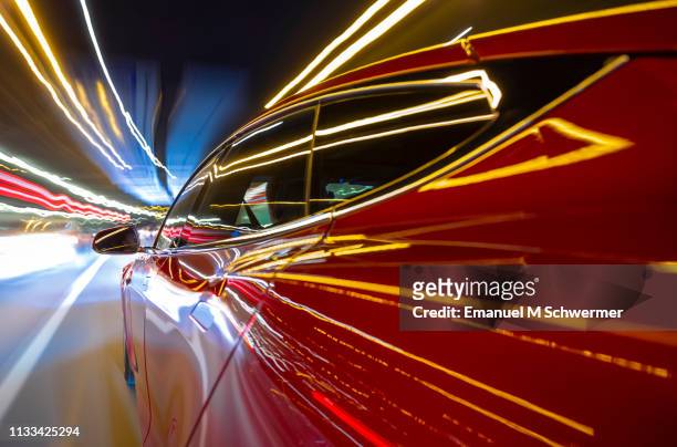 red electric powered car drives on city highway while night - streaking street lights and signs. - car point of view stock pictures, royalty-free photos & images