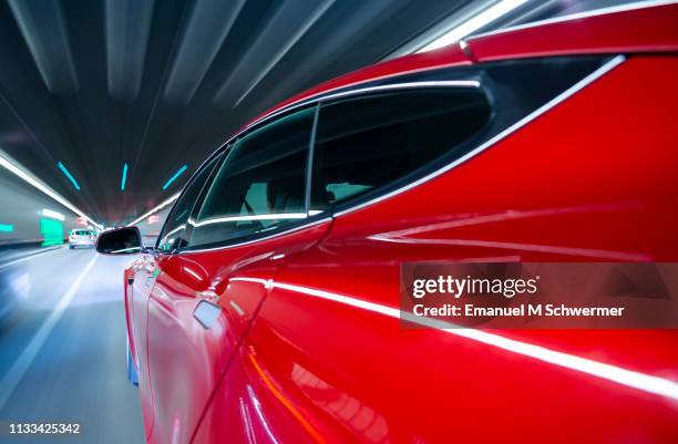 red electric powered car drives through tunnel. - audi man stockfoto's en -beelden