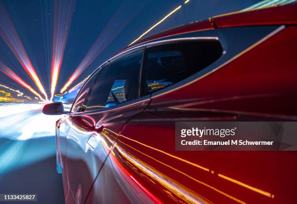 electric powered red car driving on german autobahn. - car on the road stock pictures, royalty-free photos & images