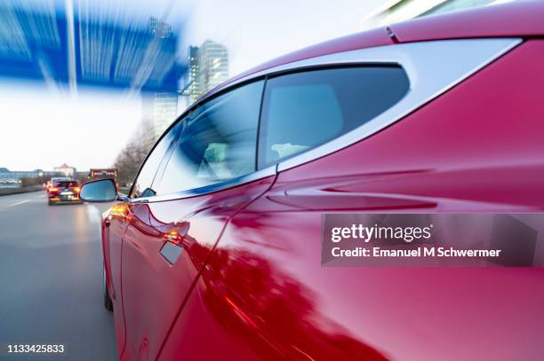 electric powered us car drives while dawn on german autobahn a9 into the city of munich. - mercedes office munich stock pictures, royalty-free photos & images