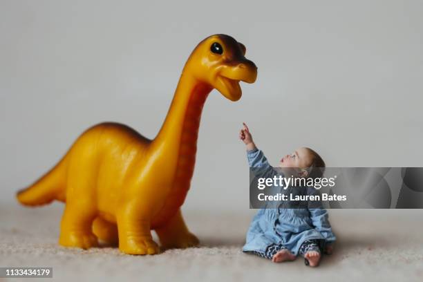 a baby girl and her dinosaur - dinosaur toy i stock pictures, royalty-free photos & images