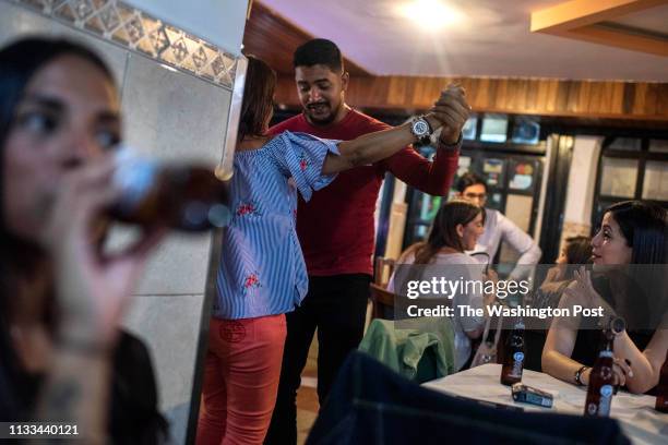 Couple dances to salsa music at a bar in Palos Grandes, an upscale neighborhood of Caracas, Venezuela on February 15, 2019. Caracas is not as...