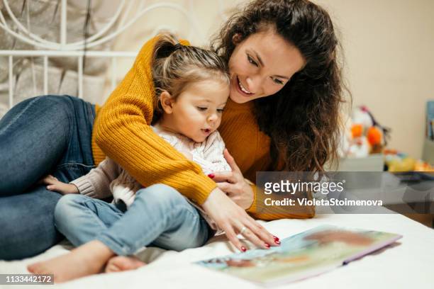 мother と娘読書おとぎ話 - supermom ストックフォトと画像