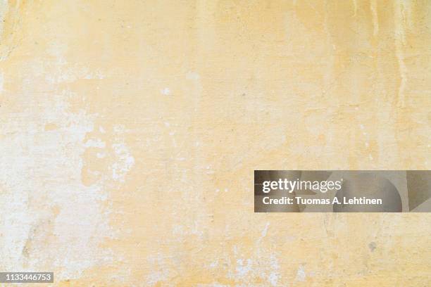 weathered and aged orange concrete wall, paint peeled off,  texture background. - yellow wall stock-fotos und bilder