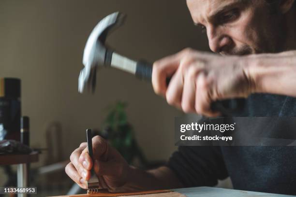 vakman punches een leder detail - geperforeerd stockfoto's en -beelden