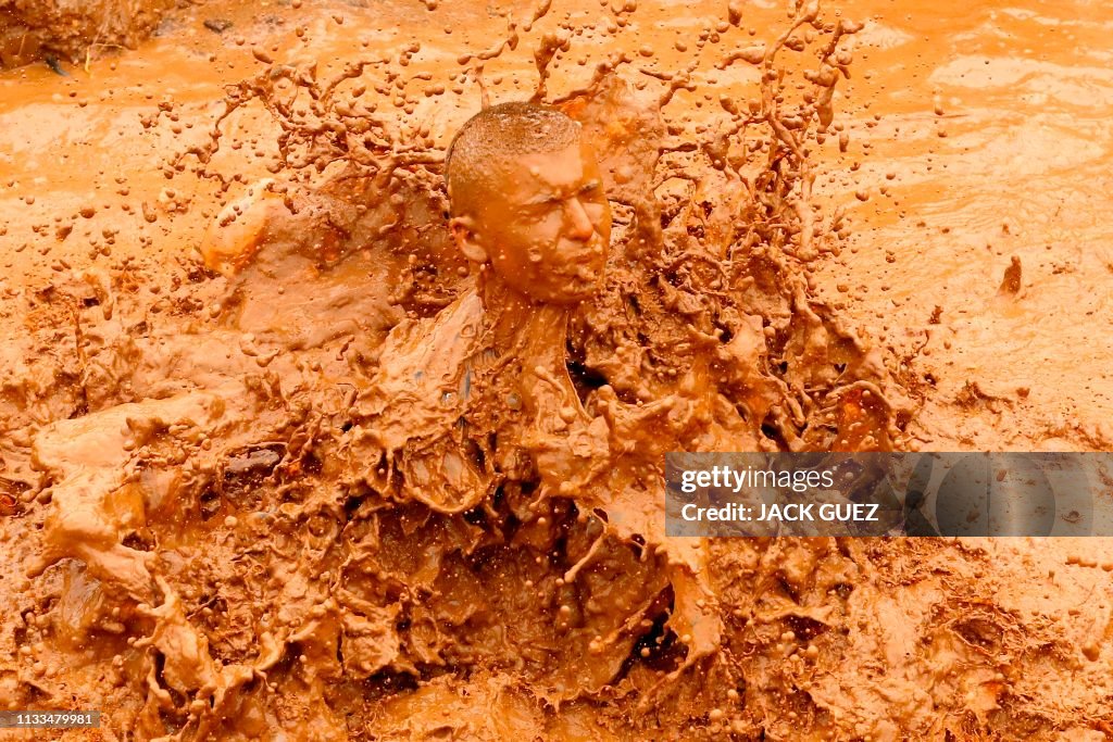 TOPSHOT - Participants jump into a mud pool in a 10km obstacle course ...