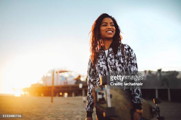 young skateboarder woman on the santa monica beach in la, california - a la moda stock pictures, royalty-free photos & images