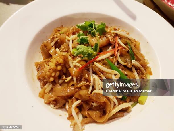 seafood char kway teow noodles on white plate - char kway teow stock pictures, royalty-free photos & images