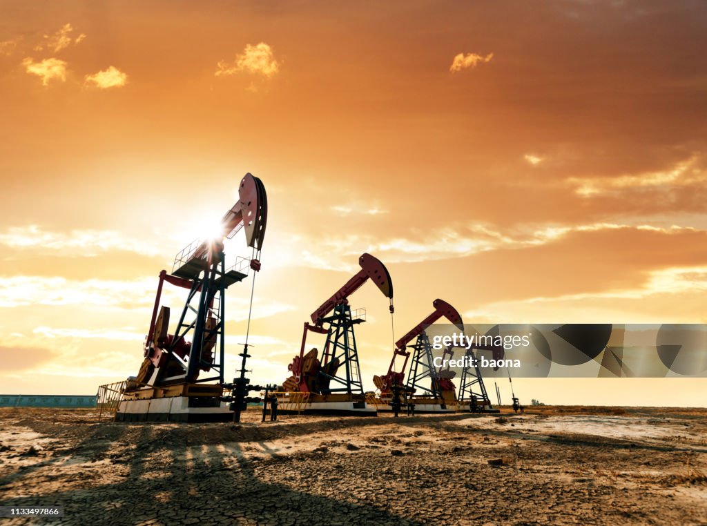 Bombas de aceite que trabajan bajo el cielo del amanecer