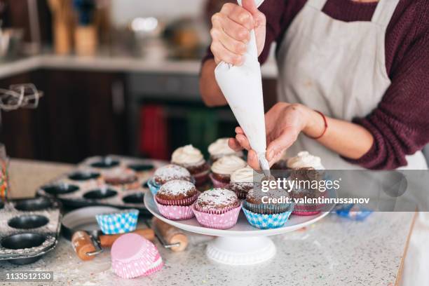 confectioner decorating chocolate muffins - cupcake stock pictures, royalty-free photos & images