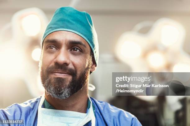 bearded male surgeon working in operating room - man looking at foreground stock pictures, royalty-free photos & images