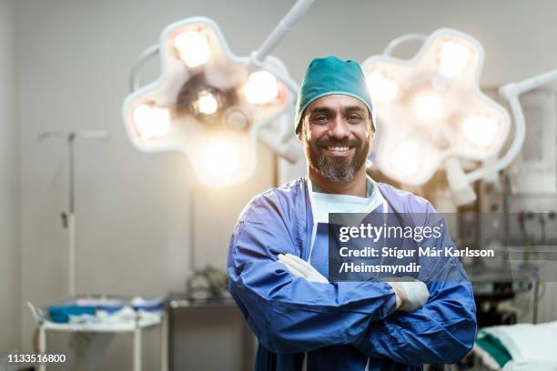 portrait de chirurgien mâle souriant avec des bras croisés - chirurgien photos et images de collection