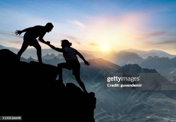 helping hikers - cliff climb stock pictures, royalty-free photos & images