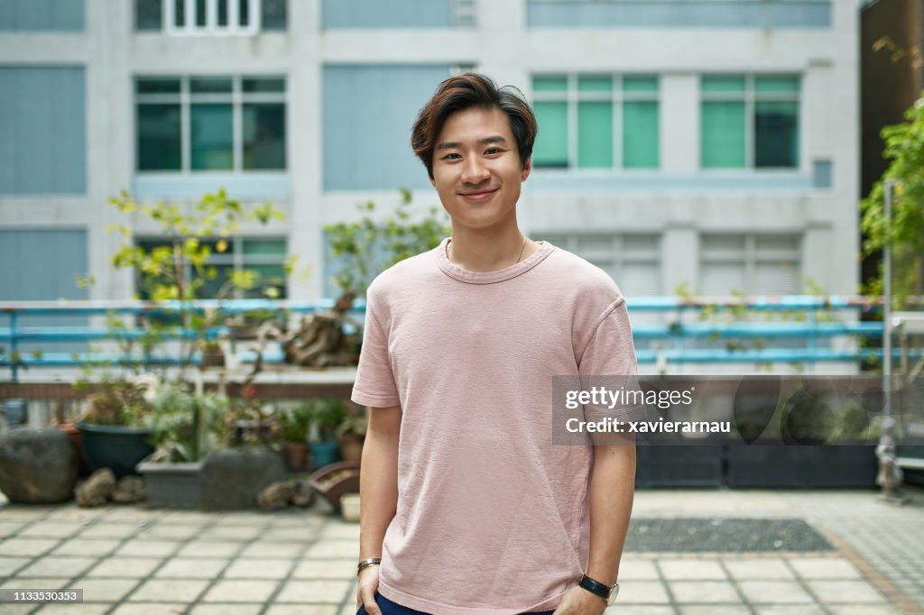 Retrato de joven sonriente en la terraza de la ciudad