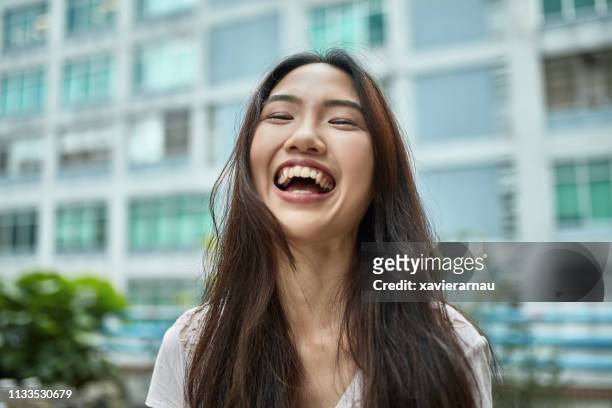 ritratto di giovane donna sorridente in città - chinese woman foto e immagini stock